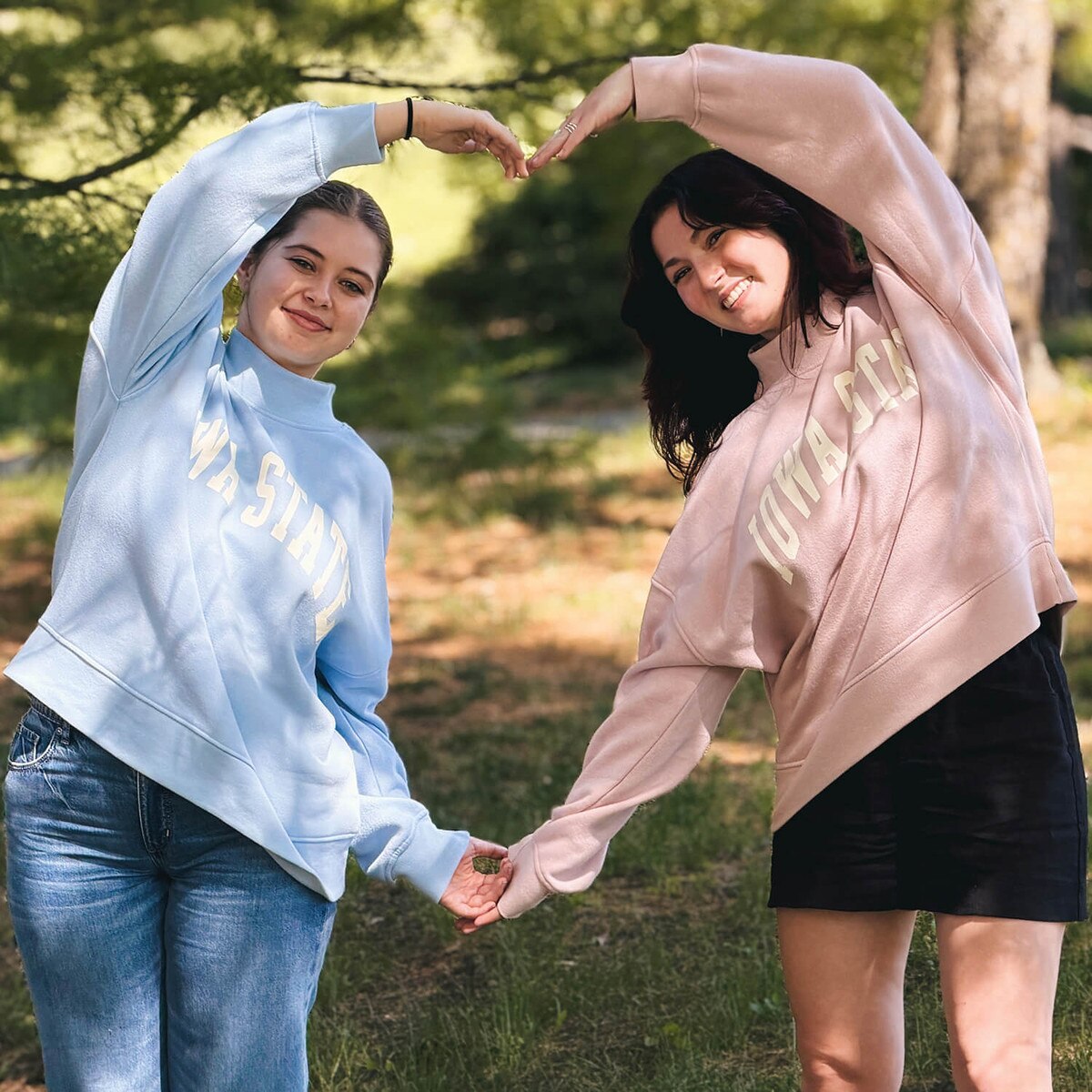 A student wearing League Women's Iowa State Dusty Pink Mock Neck Crew Sweatshirt with another student wearing the matching blue version